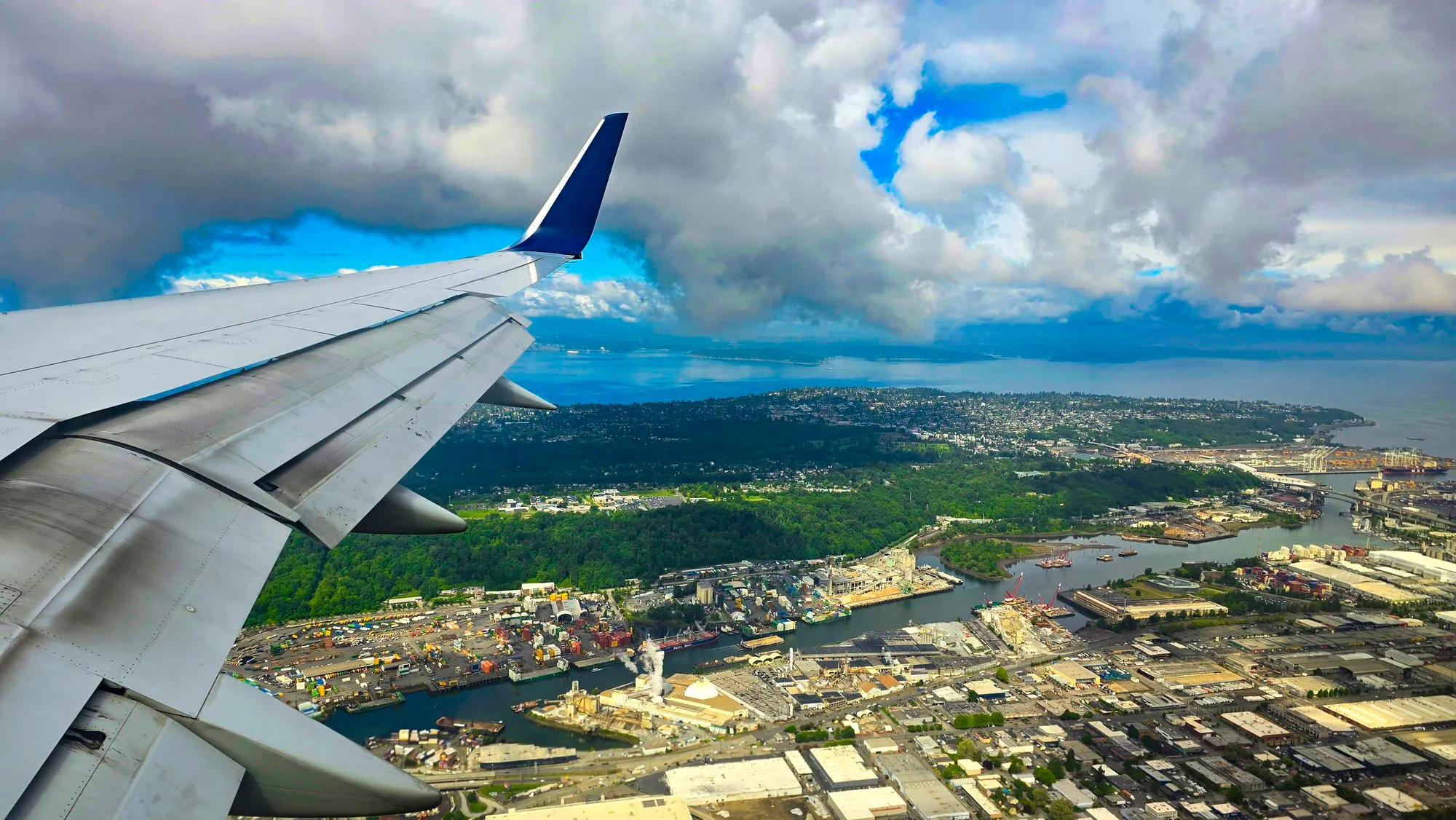 The approach into Seattle from the plane window: the Duwamish waterway, the harbor and the city under broken cloud