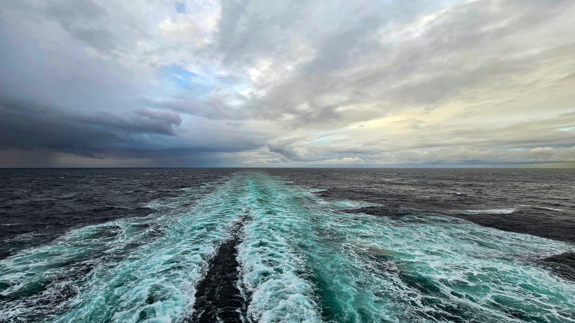 The wake of the ship at dawn in the Gulf of Alaska, gray sea under low cloud