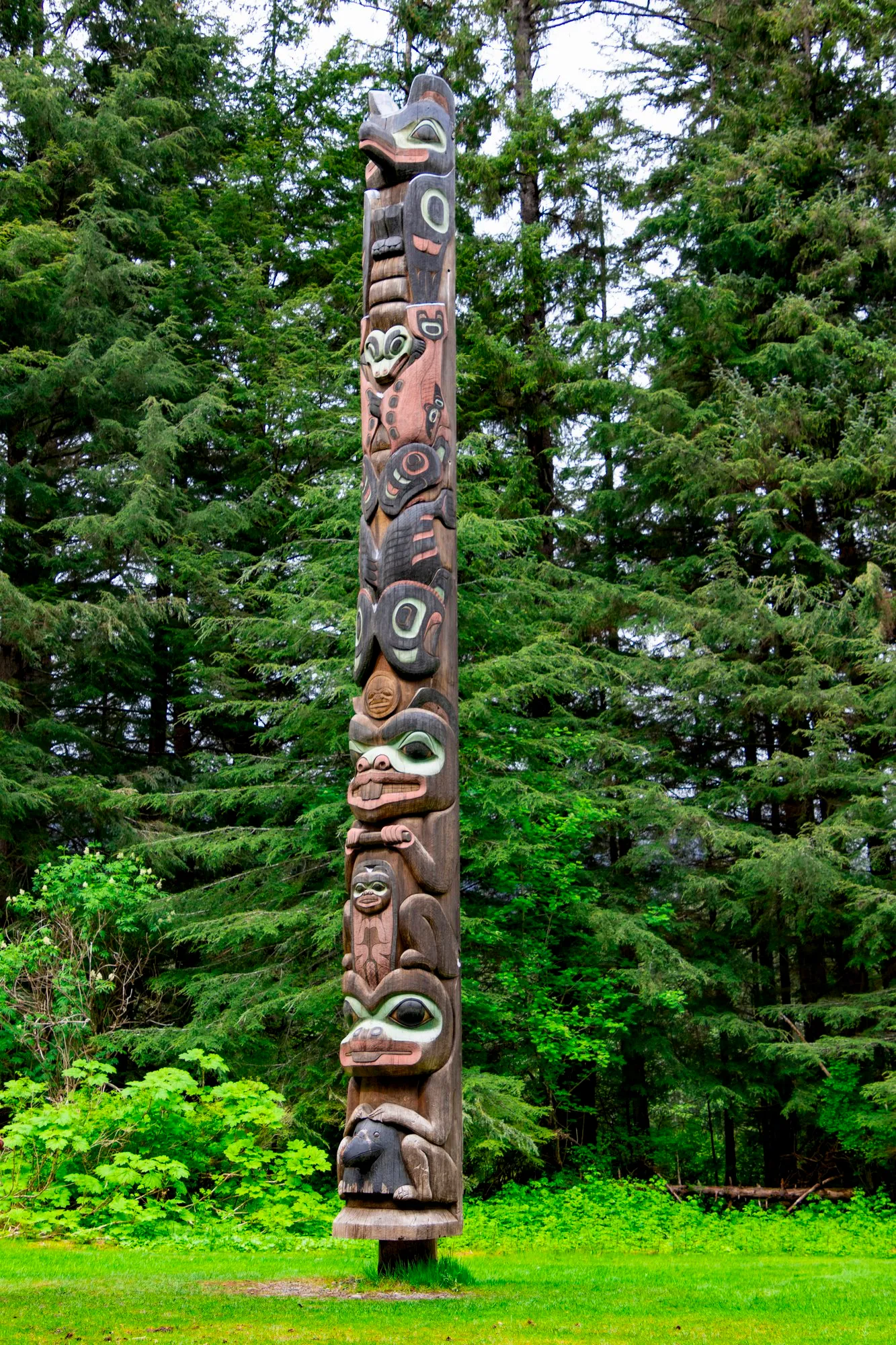 A carved pole on the lawn along the Totem Trail
