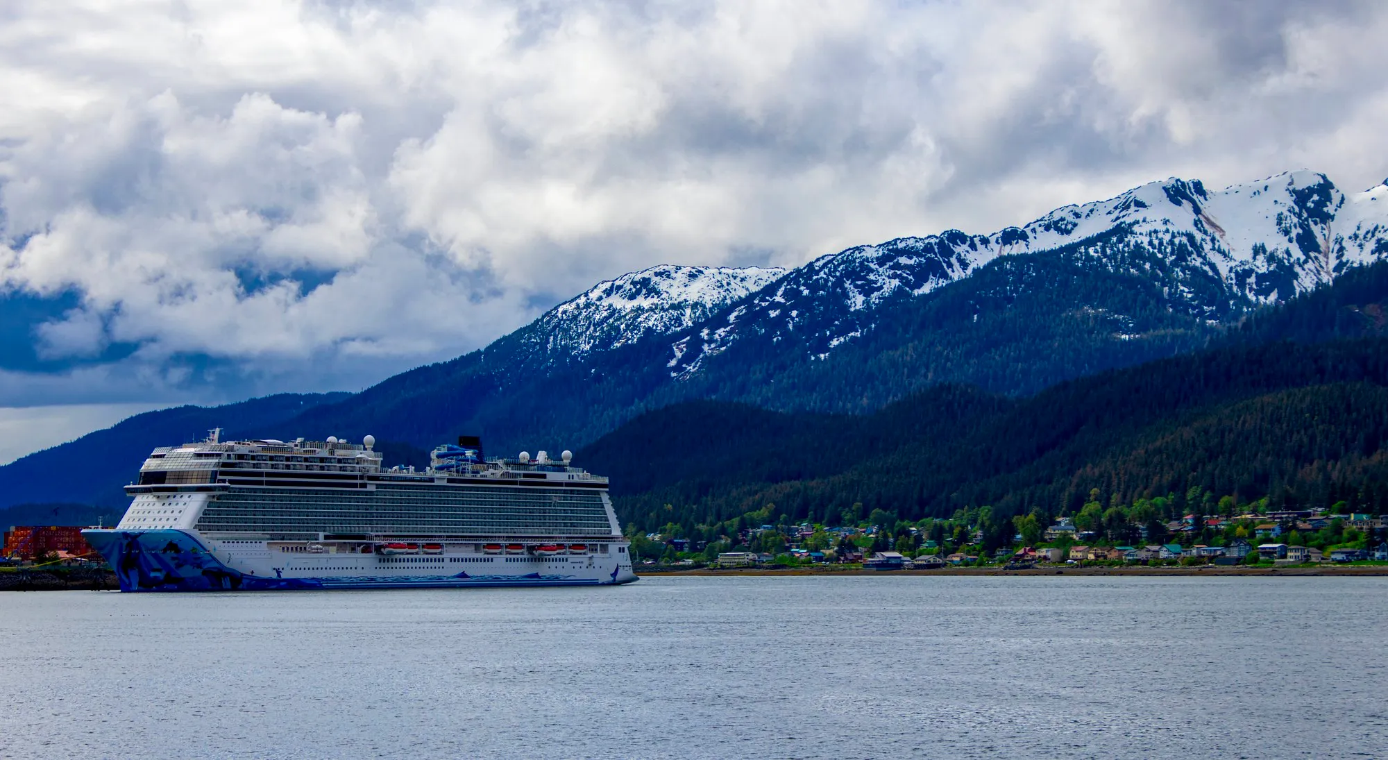 Norwegian Bliss at the AJ Dock in Juneau with snow on the peaks above