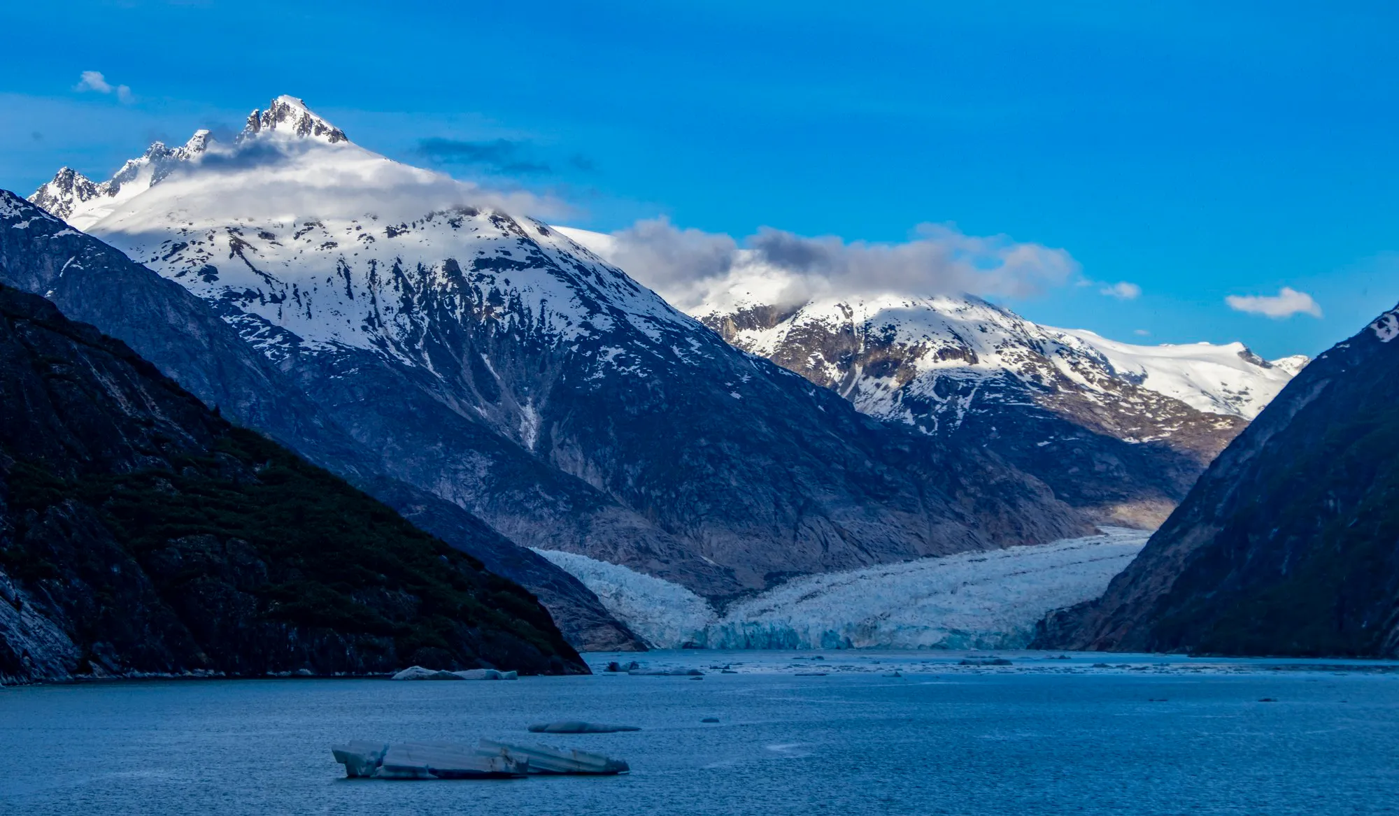 Dawes Glacier at the head of the fjord, a tour boat below the wall