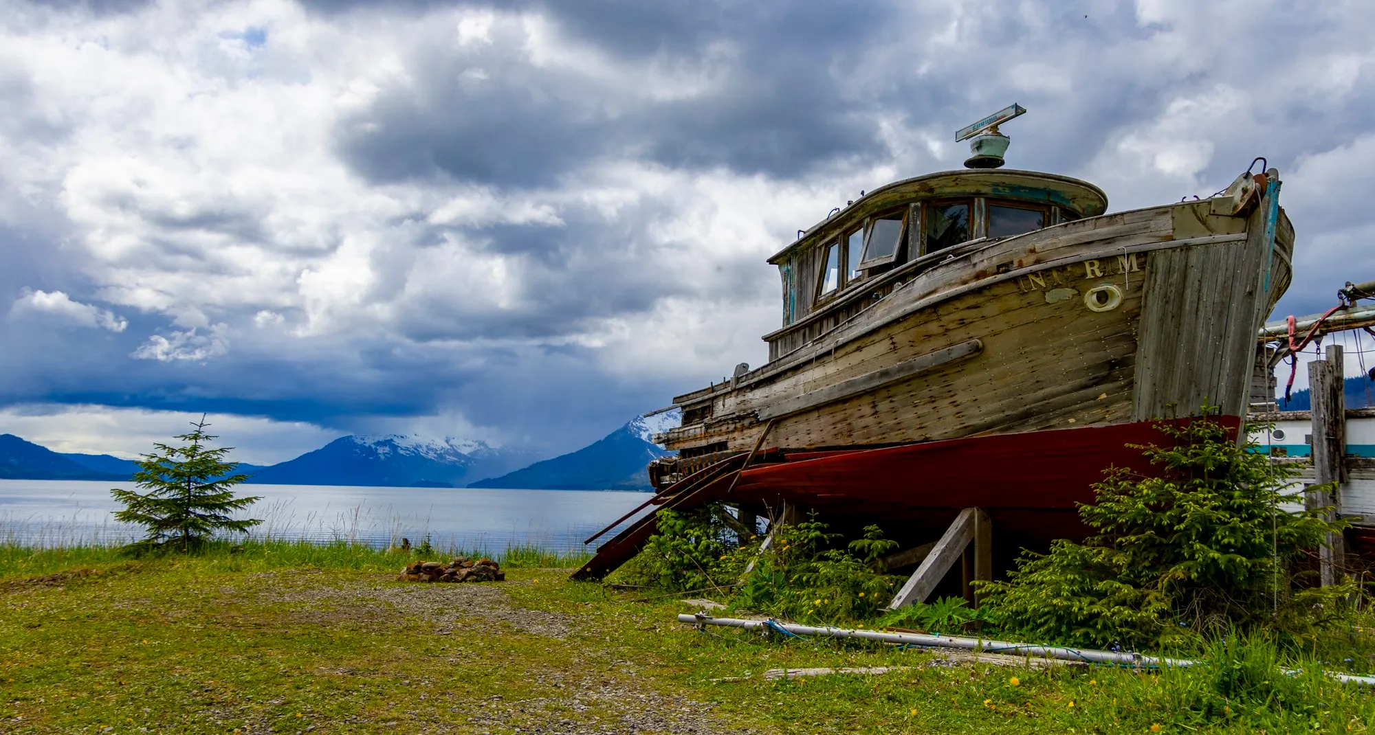 An old wooden boat on the grass at the cannery