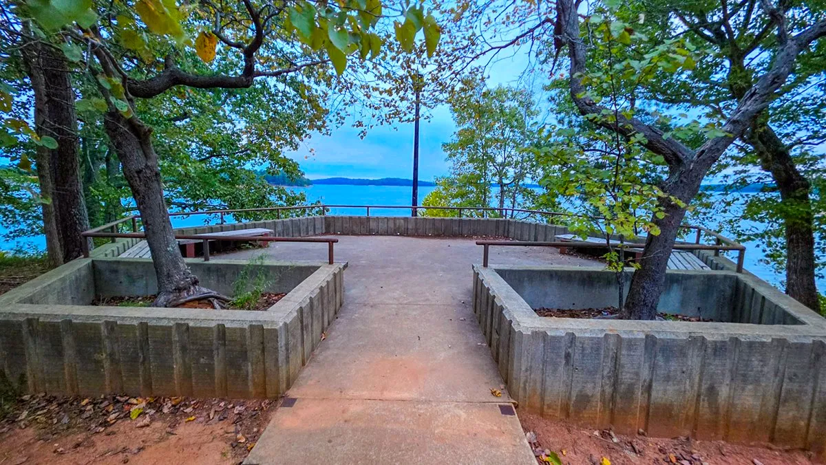 A concrete overlook at Lower Overlook with planters around two trees and Lake Lanier beyond the railing