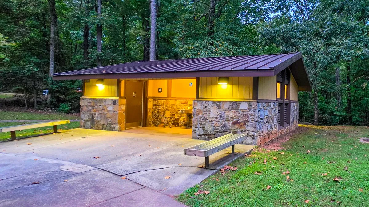 The stone restroom building at Lower Overlook with its lights on in the early morning